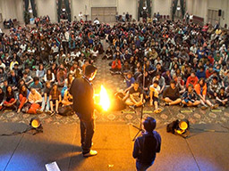 Aaron Paterson performs with fire for a large university or college campus audience to their delight