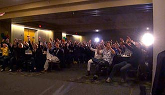 Event Entertainer Aaron Paterson has the audience hold their hands in the air.